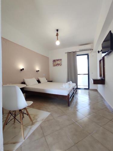 a bedroom with a bed and a table and a chair at Creta Star Apartments in Agia Galini