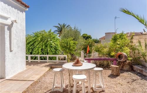 eine Terrasse mit einem Tisch und 4 Hockern in der Unterkunft Cozy Home In El Campello With Kitchen in El Campello