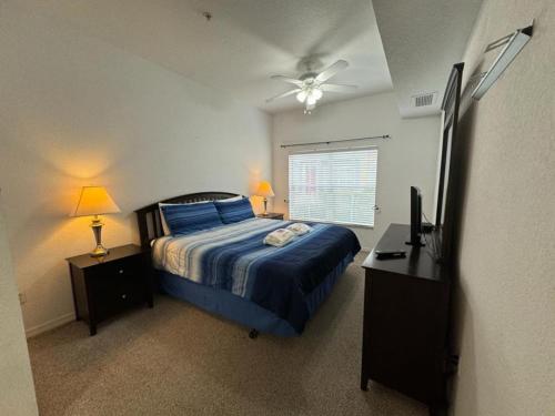a bedroom with a bed and a television in it at 4 Bedroom 3 Bathroom Villas At Seven Dwarfs 10-102 in Kissimmee