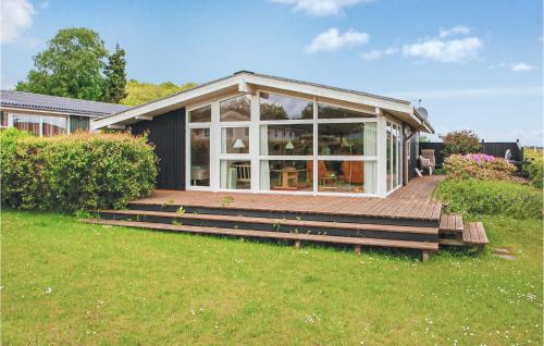 a house with a deck with a large window at Holiday Home Binderup Strandpark Bjert Denmark in Sønder Bjert
