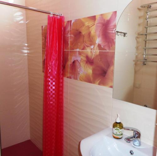 a bathroom with a red shower curtain and a sink at Hostel Q ,15 хв до жд вокзалу in Lviv
