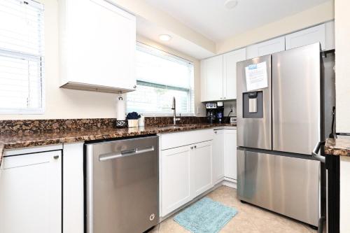 a kitchen with white cabinets and a stainless steel refrigerator at The Inn on Siesta Key in Siesta Key