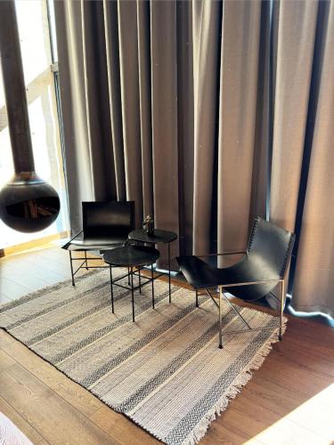 a living room with two chairs and a table at Cabañas Avandaro Santo Boutique in Valle de Bravo