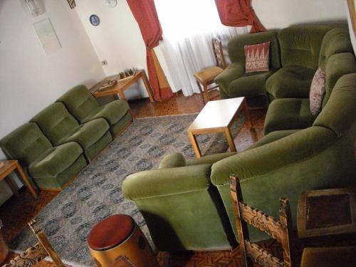 a living room with green couches and a table at Hotel Gufo in Bormio