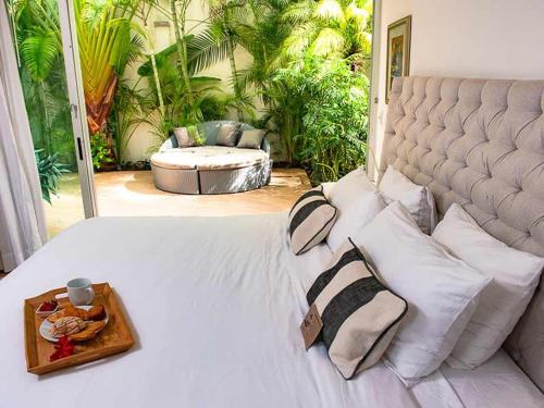 a bedroom with a bed with a tray of food on it at Magia Beachside Condo in Playa del Carmen
