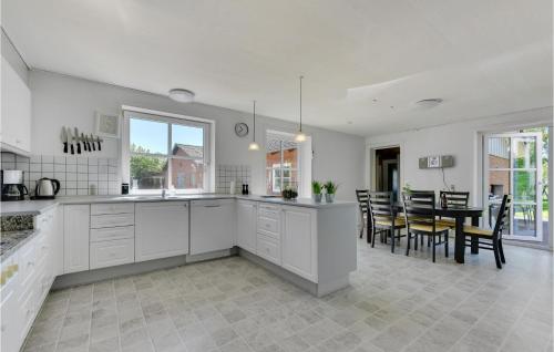 a kitchen and dining room with white cabinets and a table at Pet Friendly Home In Branderup J in Branderup