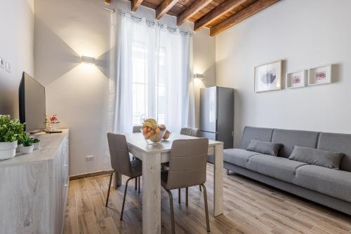 米兰Santa Giulia Suite - 15min Duomo - Olympic Arena的客厅里有一张桌子和一张沙发