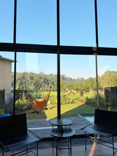 a room with a large window with a view of a yard at Cabañas Avandaro Santo Boutique in Valle de Bravo