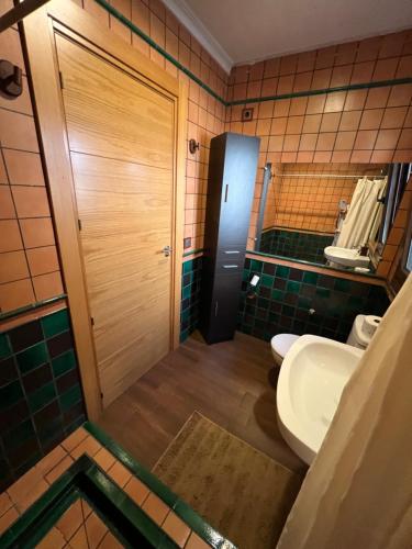 a bathroom with a sink and a toilet and a door at Villa Tranquila Lagunas de Ruidera in Ossa de Montiel
