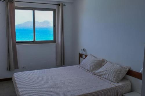 a bedroom with a bed with a view of the ocean at Duarte Apartments - Las Rochas in Mindelo