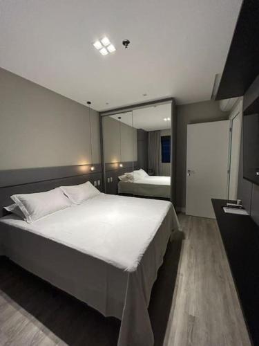 a bedroom with a large bed and a mirror at Flat 1609 Infinity Tower in Itapema
