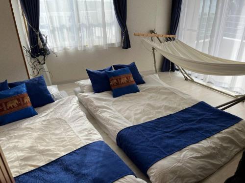 two beds in a room with blue pillows at Piso Essauna - Vacation STAY 16990 in Igei