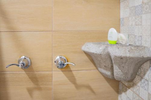 a bathroom with two knobs on a wall at Casa Noble Hotel in Antigua Guatemala