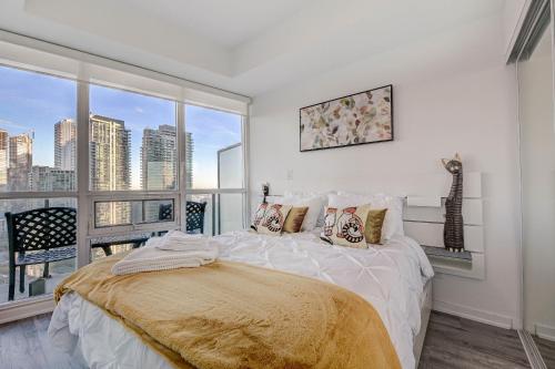 ein Schlafzimmer mit einem Bett und einem großen Fenster in der Unterkunft Stunning 2 BD in heart of Toronto with Parking in Toronto
