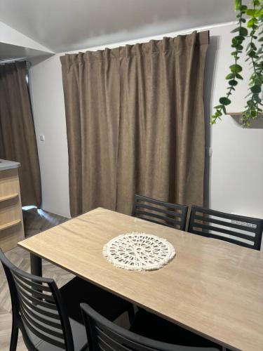 a wooden table with chairs and a curtain at domaine de dugny in Onzain