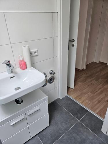 a bathroom with a white sink and a tile floor at Ferienwohnung 55qm Mörnsheim in Mörnsheim