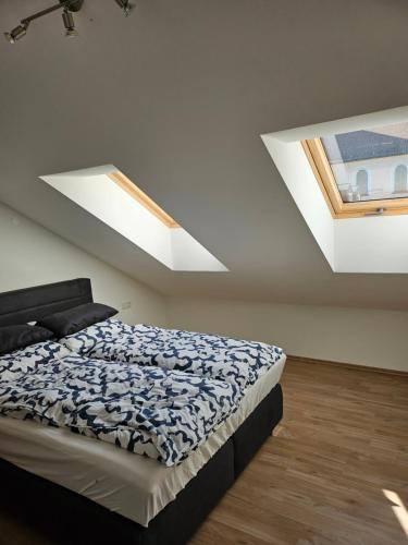a bedroom with a bed and two skylights at Ferienwohnung 55qm Mörnsheim in Mörnsheim