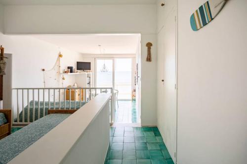 a room with a staircase and green tile floors at A Window to the Sea in Nettuno