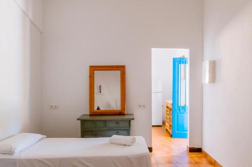 a white room with a bed and a mirror at Villa Alexa this charming villa is just a 10 min drive to either Playa Den Bossa or San Antonio in Sant Josep de Sa Talaia