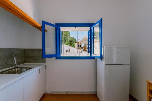 a kitchen with a window and a sink and a refrigerator at Villa Alexa this charming villa is just a 10 min drive to either Playa Den Bossa or San Antonio in Sant Josep de Sa Talaia