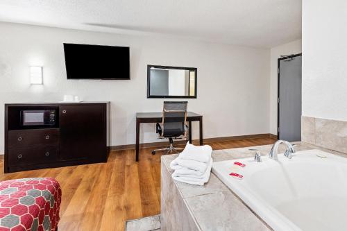 a hotel room with a bath tub and a desk at Econo Lodge Akron Copley Northwest in Montrose