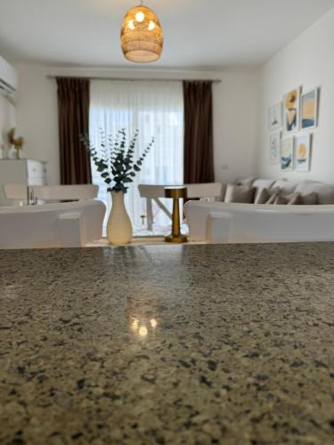 a living room with a couch and a vase of flowers at 3BR Chalet in MV Ras El Hekma in Ras Elhekma