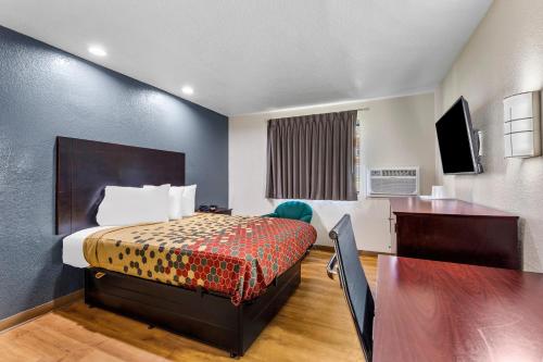 a small hotel room with a bed and a desk at Econo Lodge Akron Copley Northwest in Montrose