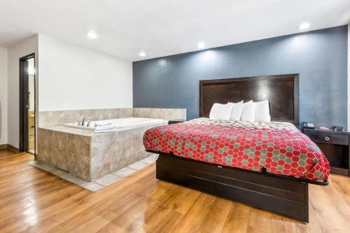 a hotel room with a bed and a bath tub at Econo Lodge Akron Copley Northwest in Montrose