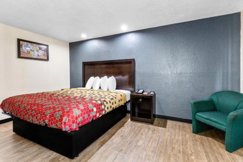 a hotel room with a bed and a chair at Econo Lodge Akron Copley Northwest in Montrose
