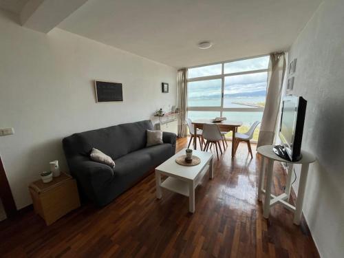 a living room with a couch and a table at Piso primera línea de playa y vistas al mar en Cariño in Cariño