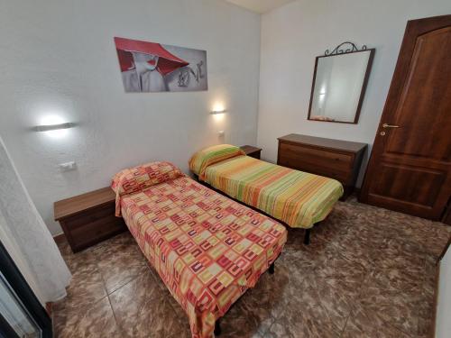 a hotel room with two beds and a mirror at Appartamento Dune in Santa Lucia