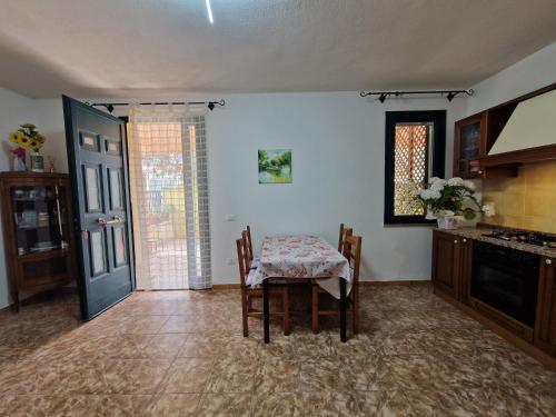 a dining room with a table and a kitchen at Appartamento Dune in Santa Lucia