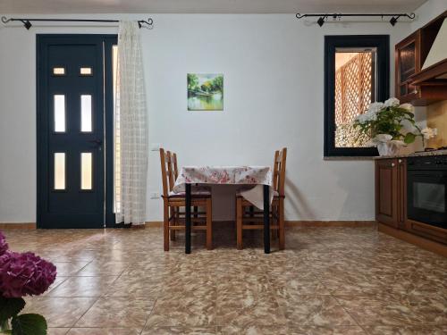 a dining room with a table and chairs and a door at Appartamento Dune in Santa Lucia