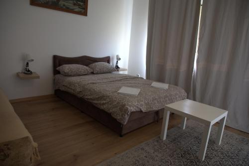 a small bedroom with a bed and a table at City Edge Belgrade in Belgrade