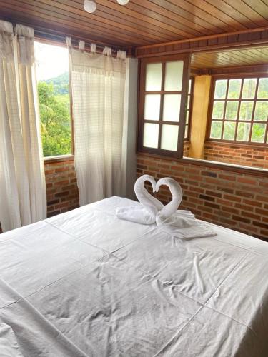 a bed with two swans made to look like hearts at Santa Anna Ecohouse in Penedo
