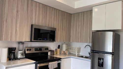 a kitchen with a refrigerator and a stove top oven at Inara 1 - Apartamento grande cerca del aeropuerto - Zona 13 de la Ciudad de Guatemala in Guatemala