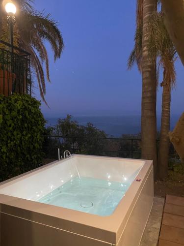 a jacuzzi tub with a view of the ocean at Villa des Arts - Taormina in Taormina