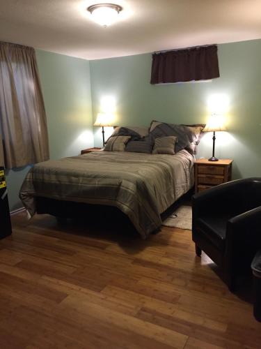 a bedroom with a bed with two lamps and a couch at Trinity House in Fairbanks