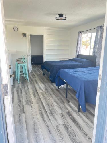 a bedroom with two beds and a wooden floor at Little Betty’s Hideaway in Torrance