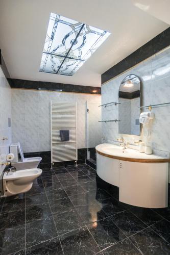 a bathroom with a tub and a sink and a mirror at GRAND SUITE by F & G in Kastoria