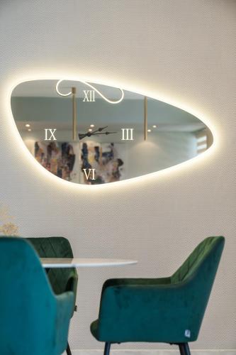a room with a table and chairs and a clock at GRAND SUITE by F & G in Kastoria