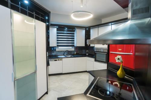a large kitchen with white cabinets and a red refrigerator at GRAND SUITE by F & G in Kastoria