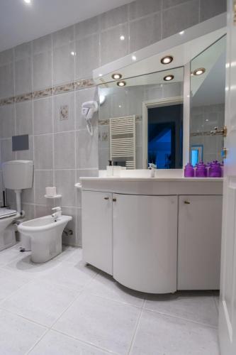 a bathroom with a sink and a toilet and a mirror at GRAND SUITE by F & G in Kastoria