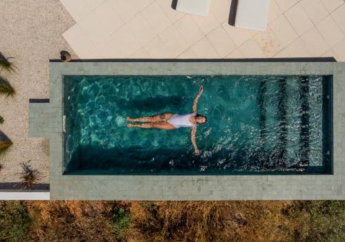 an overhead view of a person swimming in the water at Casa Bartolomeu in Castro Marim