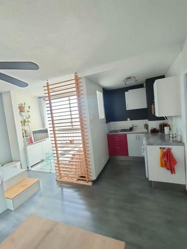 - une cuisine avec une grande porte ouverte dans une pièce dans l'établissement Studio 2min de la plage et parking privé, à Mauguio