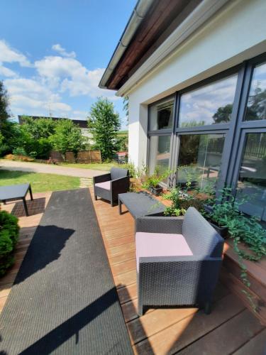a patio with chairs and tables on a wooden deck at Hotel Vincent in Luhačovice