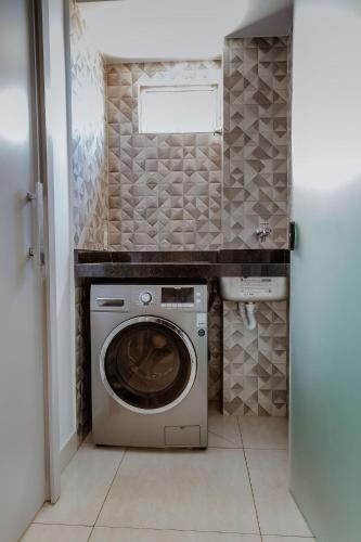 a laundry room with a washer and dryer in it at Bee Guest - Apartamentos de Temporada Luxxor Flat in Cuiabá