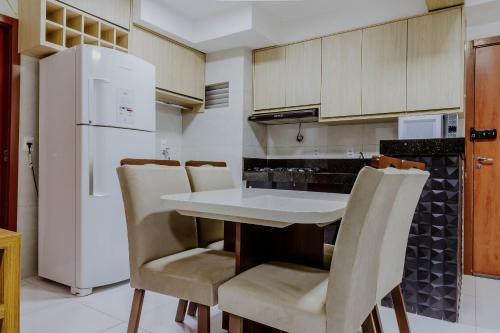 a kitchen with a table and chairs and a refrigerator at Bee Guest - Apartamentos de Temporada Luxxor Flat in Cuiabá