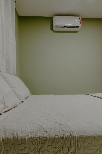 a bedroom with a bed with a scale on the wall at Bee Guest - Apartamentos de Temporada Luxxor Flat in Cuiabá