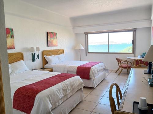 ein Hotelzimmer mit zwei Betten und einem Tisch in der Unterkunft HOTEL SAN CARLOS PLAZA in San Carlos
